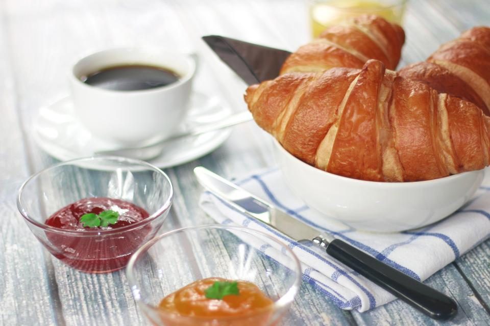Croissants, Kaffee und Marmelade auf dem Frühstückstisch