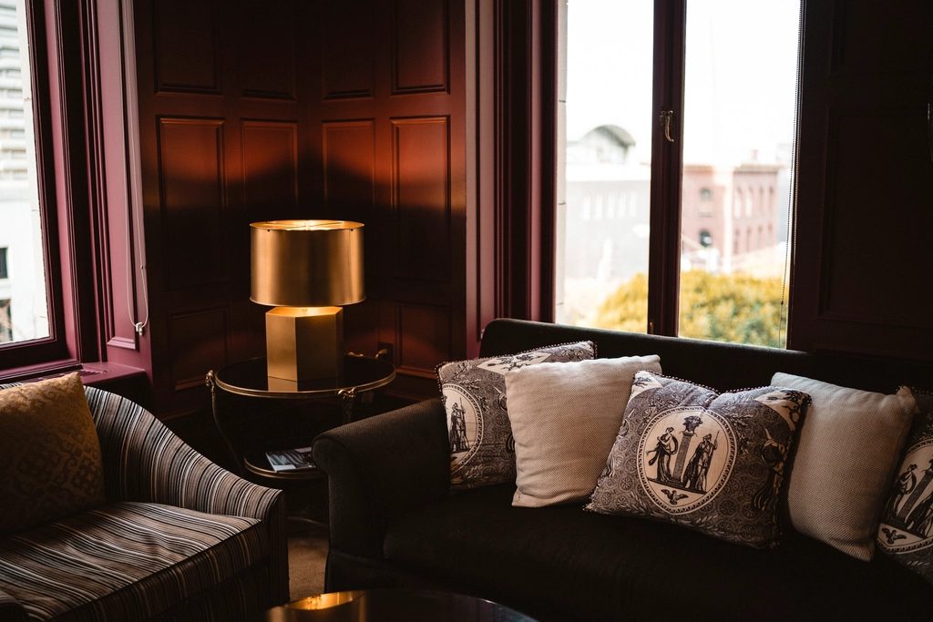 Die Lounge des Salzkontors in der Abenddämmerung — Samtsofas und eine Messinglampe an den hohen Fenstern