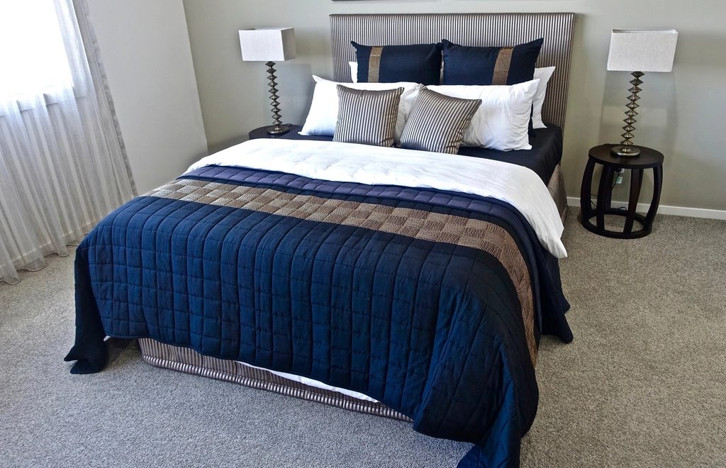 Klassik-Zimmer mit blauer Tagesdecke und zwei Nachttischlampen